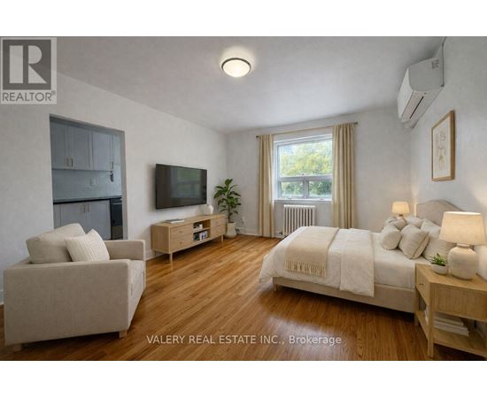 A bedroom with a bed, couch, and television.