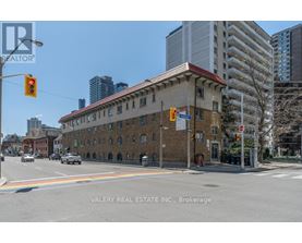 A street view of a building with a rainbow painted on the road.