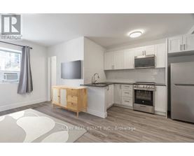 A kitchen with a wooden island and stainless steel appliances.