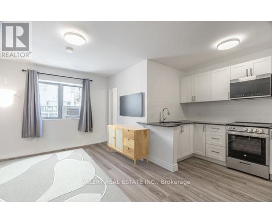 A kitchen with a wooden table and a flat screen TV mounted on the wall.