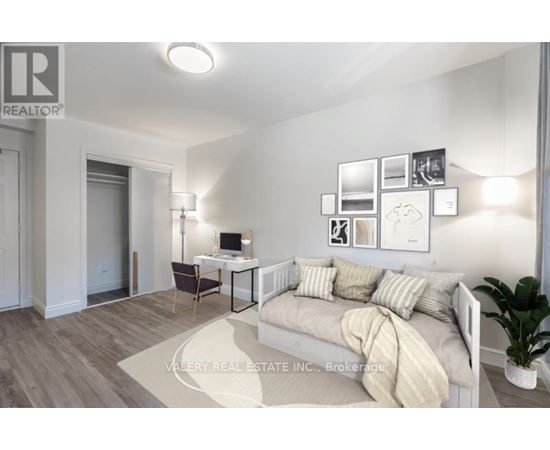 A bedroom with a bed, desk, and chair.