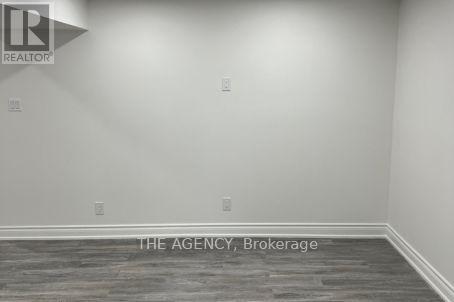 A room with a grey floor and a white wall with a logo and text on it.