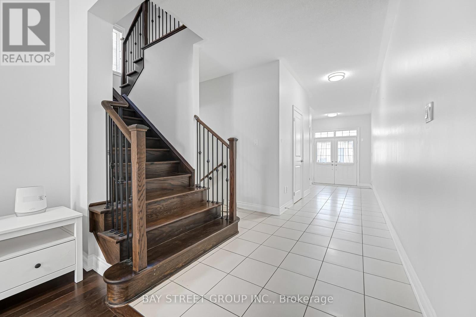 A spacious hallway with a staircase and a white console table.
