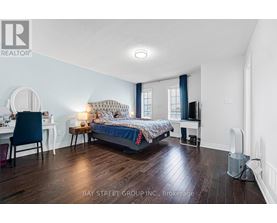 A bedroom with a bed, desk, chair, and window.
