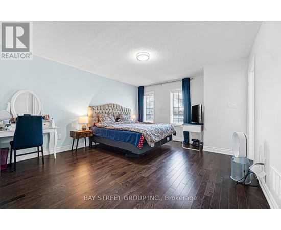 A bedroom with a bed, desk, chair, and window.