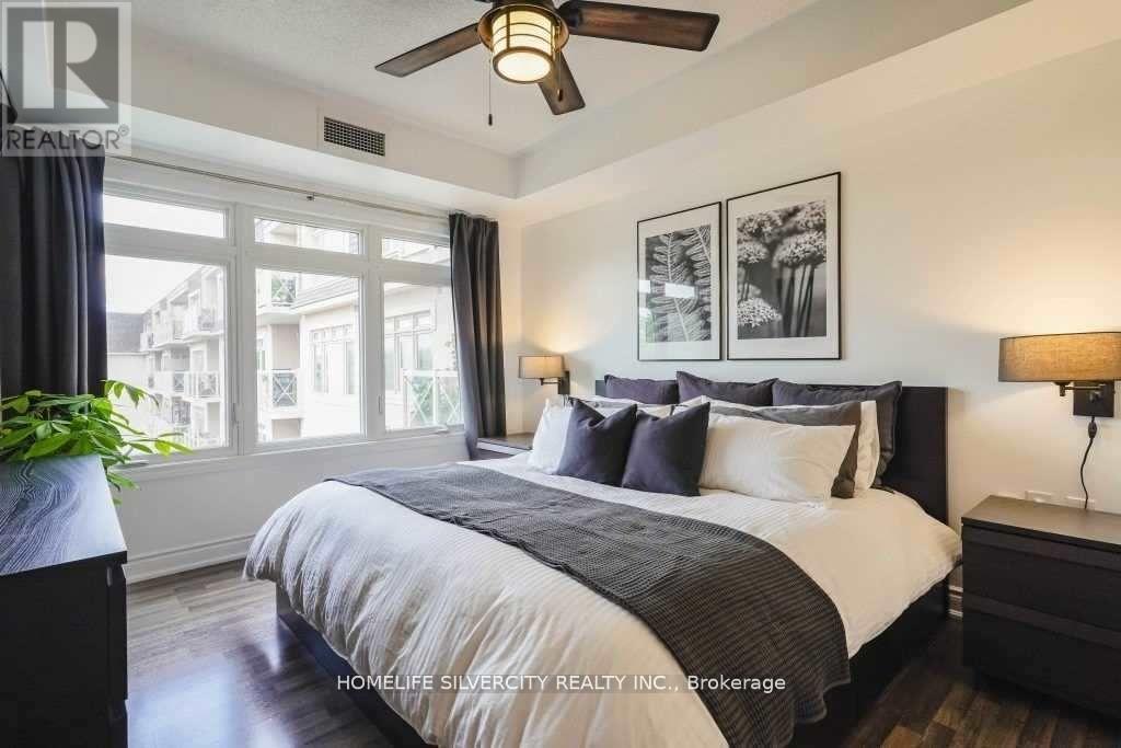 A bedroom with a large bed and a ceiling fan.