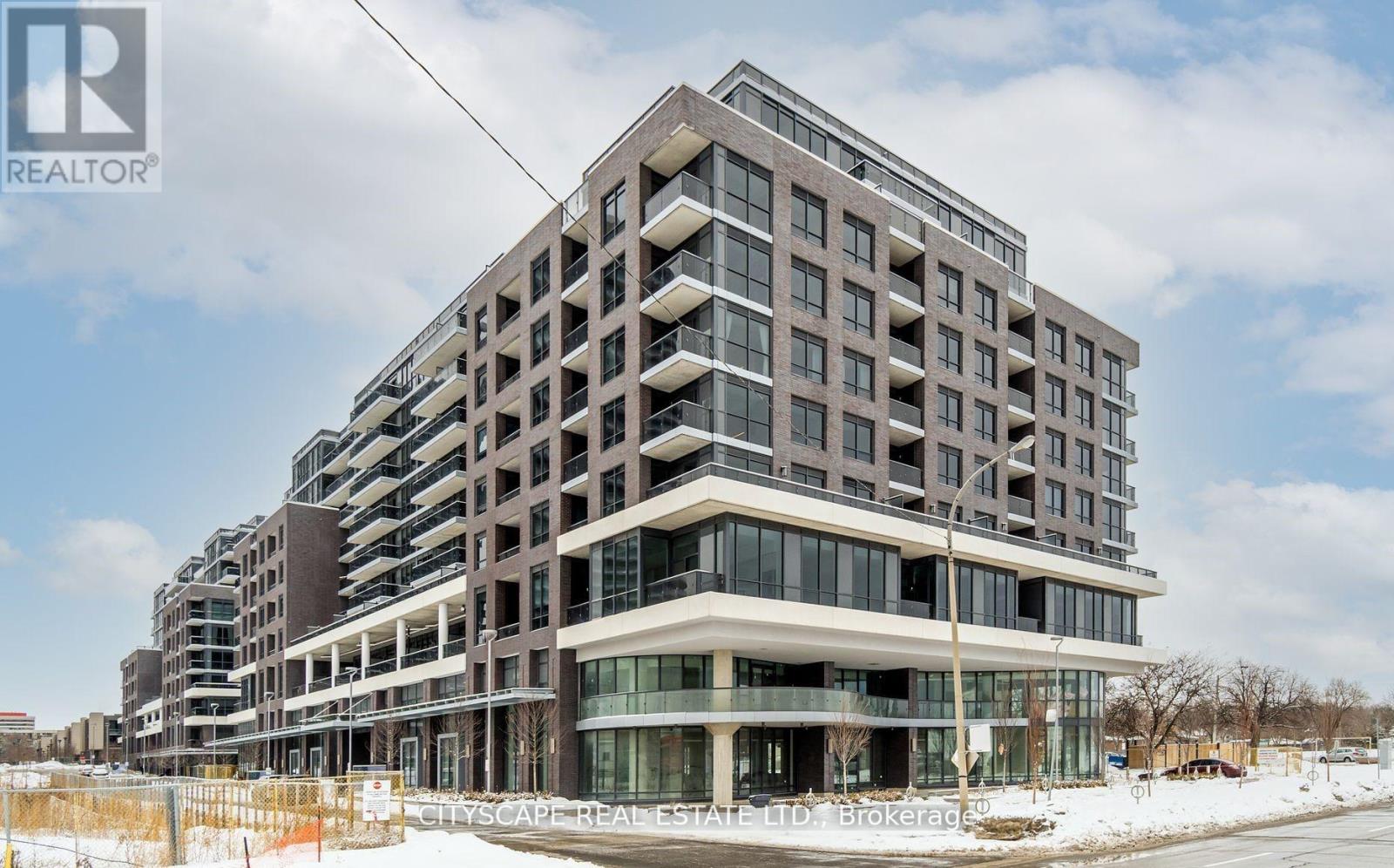 A large, modern building with many windows and balconies is under construction.