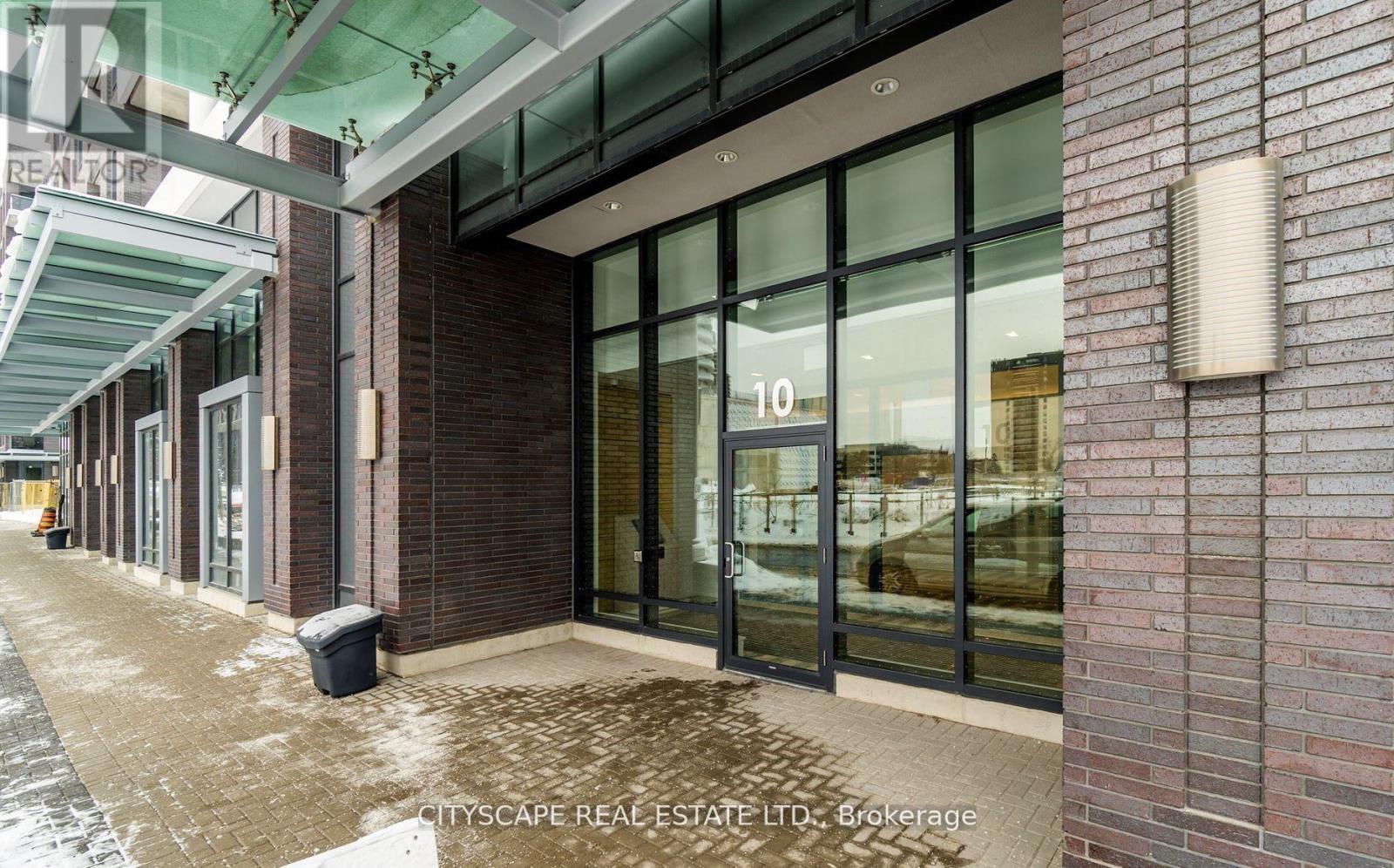 The image shows the exterior of a building with a glass door marked with the number 10.