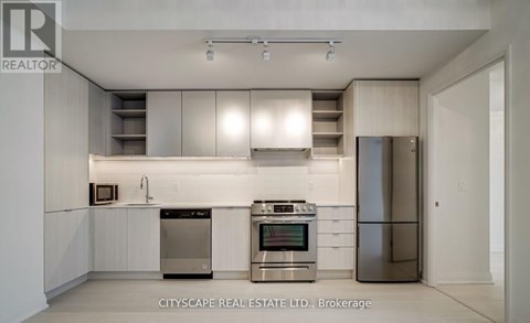 A modern kitchen with stainless steel appliances and white cabinetry.