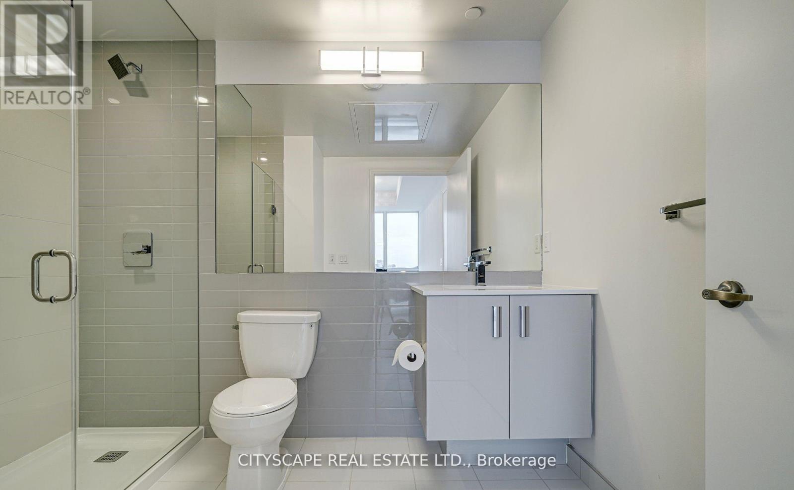 A white toilet is in a bathroom with a glass shower door.