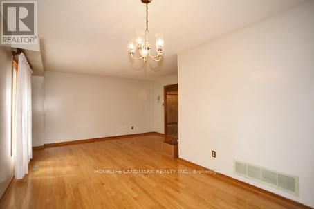 A room with a wooden floor and a chandelier.