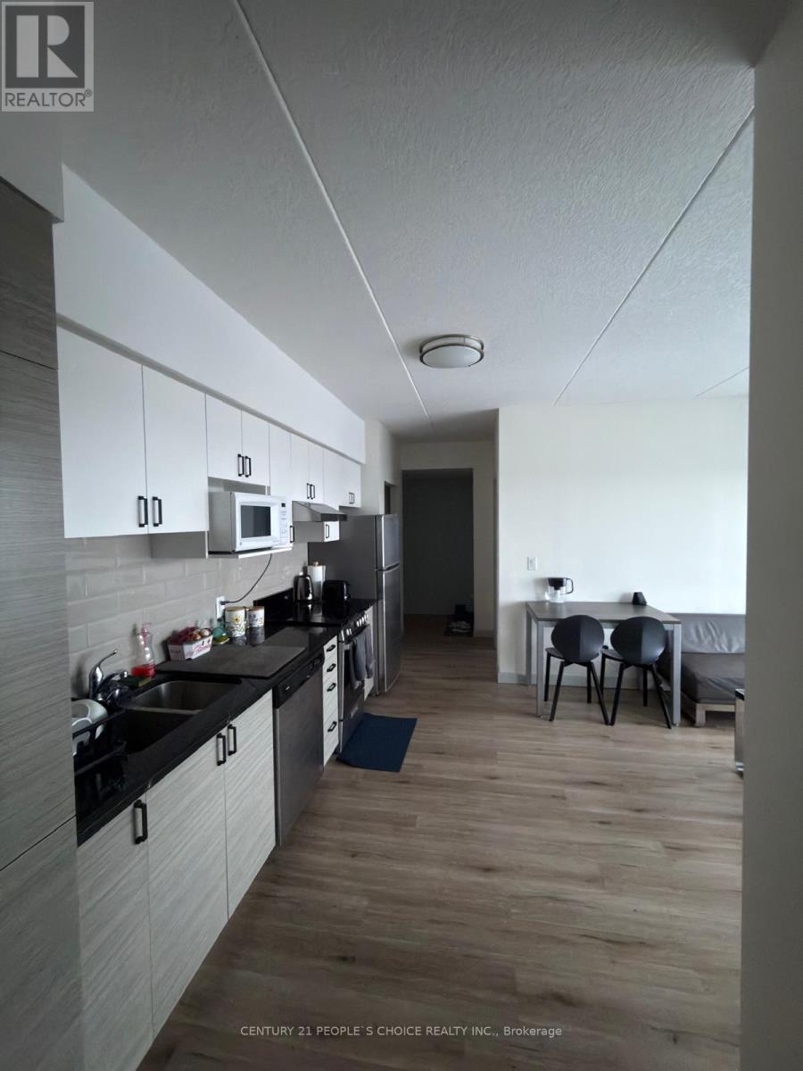 A kitchen with a dining table and chairs in the background.