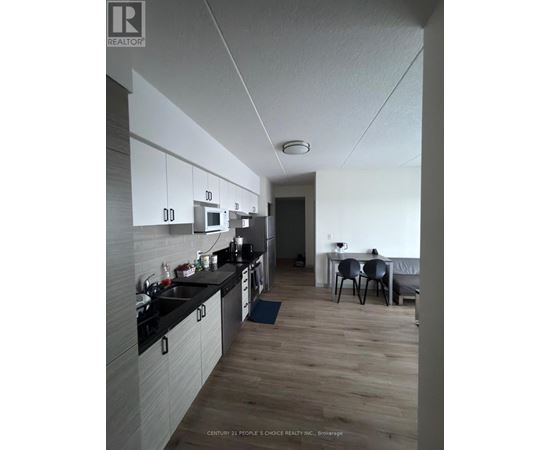 A kitchen with a dining table and chairs in the background.