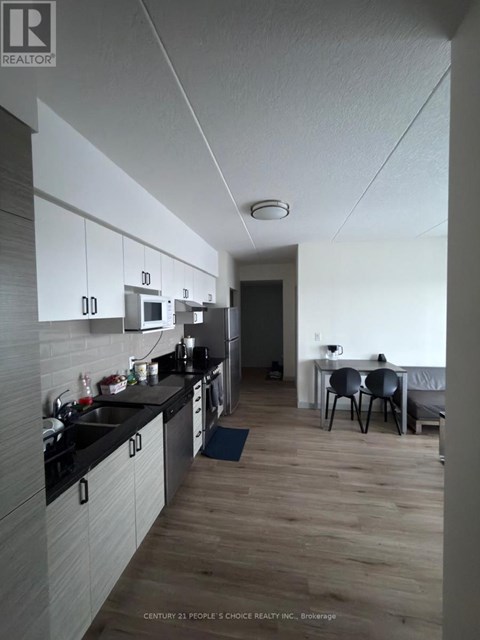 A kitchen with a dining table and chairs in the background.
