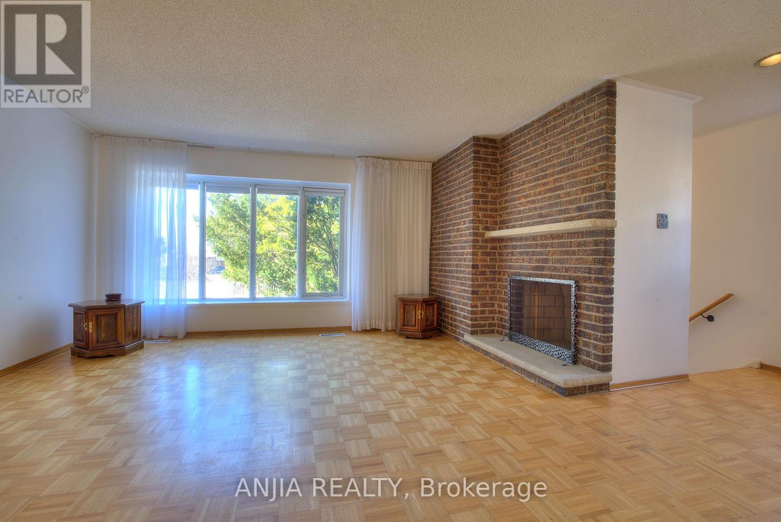 A living room with a fireplace and a large window.