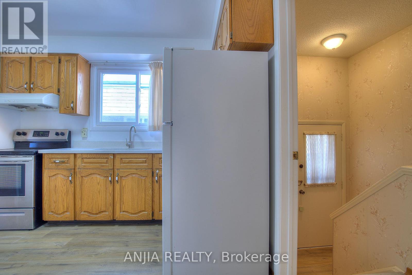 A kitchen with wooden cabinets and a white refrigerator.