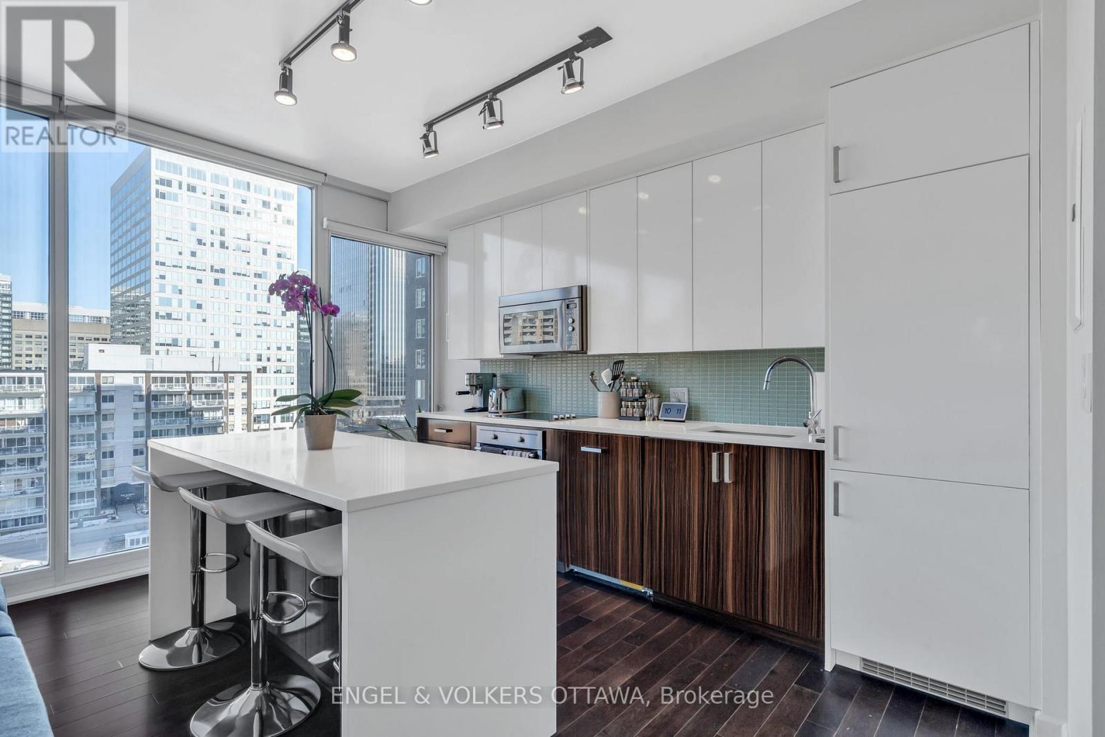 A modern kitchen with white cabinets and a bar area.