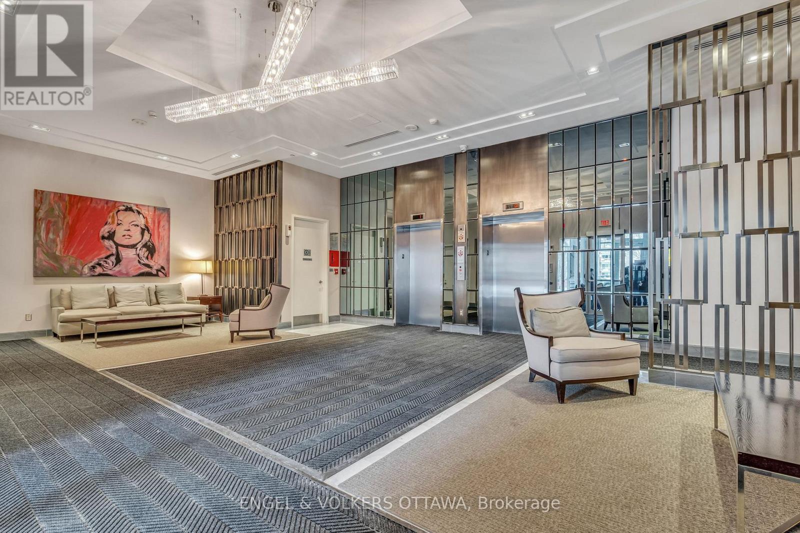 A spacious office lobby with a large painting, a sofa, a chair, and a carpet.