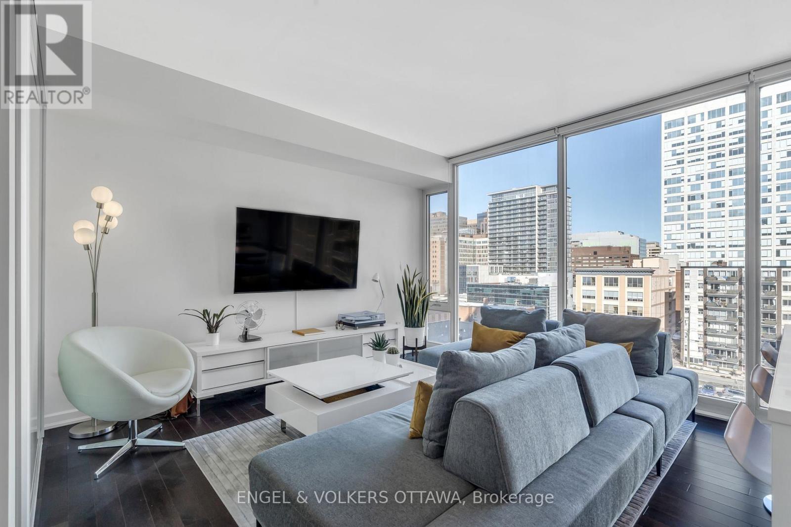 A modern living room with a grey sofa and a white chair.