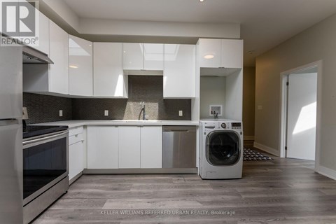 A modern kitchen with white cabinets and stainless steel appliances.