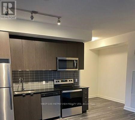 A kitchen with a stainless steel refrigerator, microwave, oven, and dishwasher.