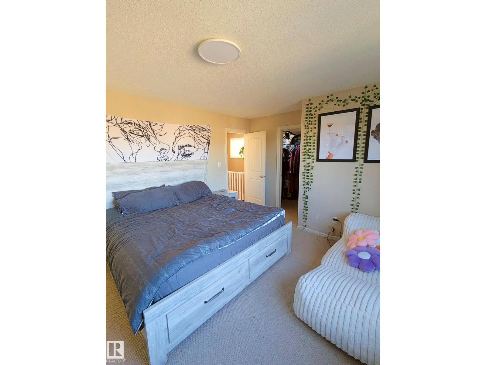 A bedroom with a bed and a chair.
