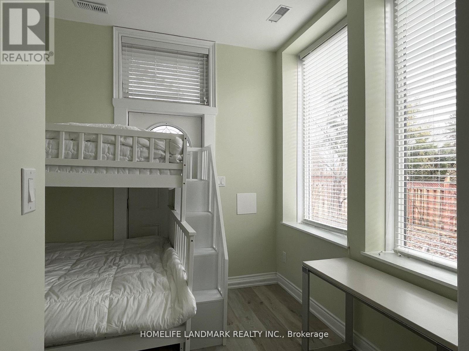 A bedroom with a bunk bed and a window.