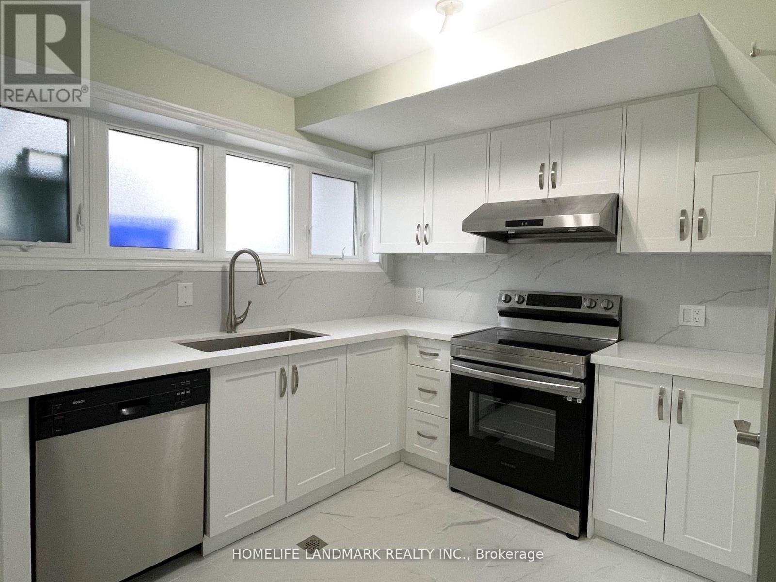 A kitchen with white cabinets and appliances.