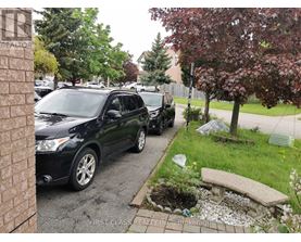 A black car is parked on a driveway.