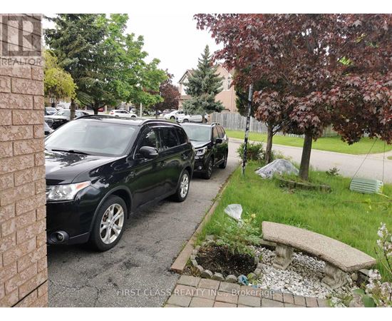 A black car is parked on a driveway.