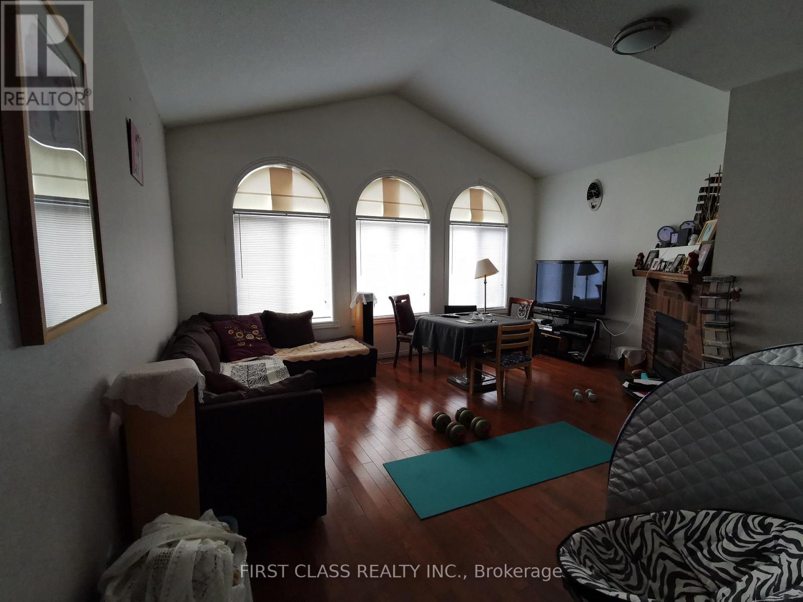 A living room with a couch, chairs, and a dining table.