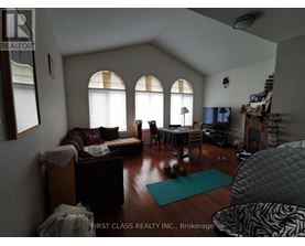 A living room with a couch, chairs, and a dining table.