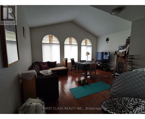 A living room with a couch, chairs, and a dining table.