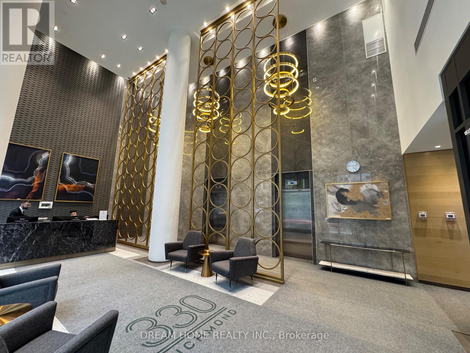A reception area with a marble floor and gold accents.