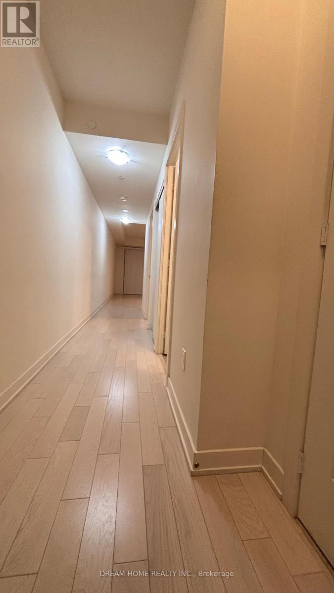 A long hallway with wood floors and white walls.
