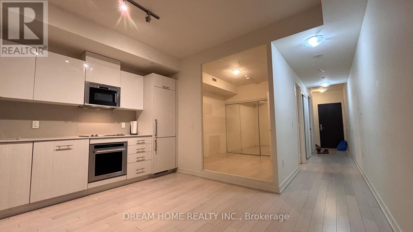 A kitchen with white cabinets and a microwave above the oven.