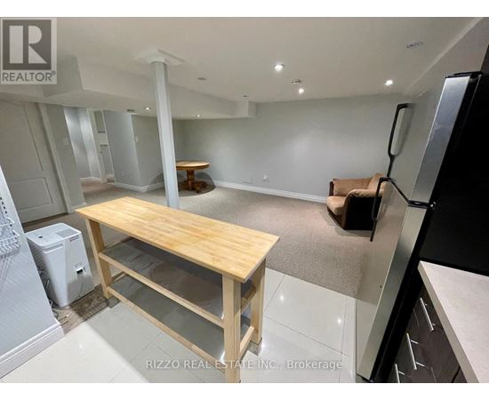 A kitchen with a table and a refrigerator.