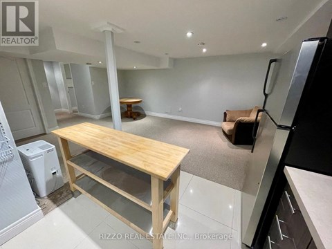 A kitchen with a table and a refrigerator.