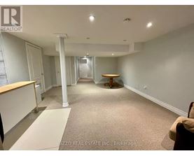 A spacious room with a carpeted floor and a wooden table in the middle.