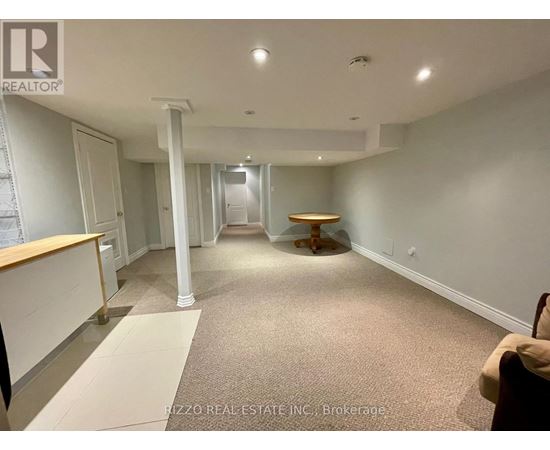 A spacious room with a carpeted floor and a wooden table in the middle.
