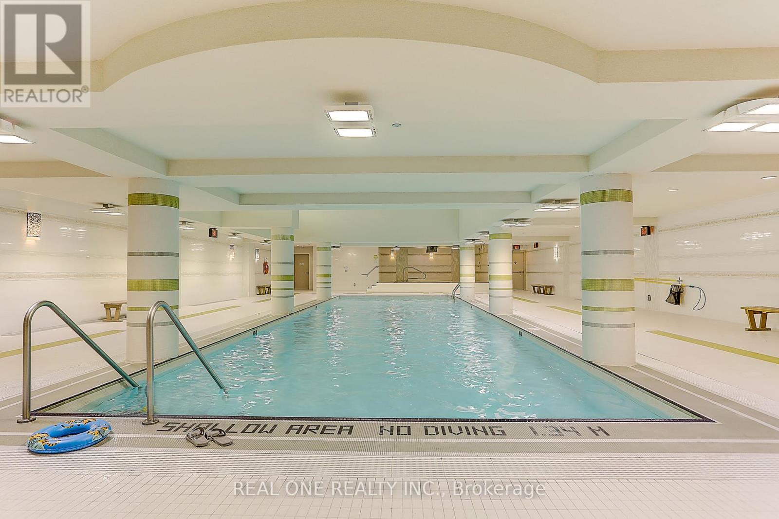 A large indoor swimming pool with a slide and a no-diving sign.