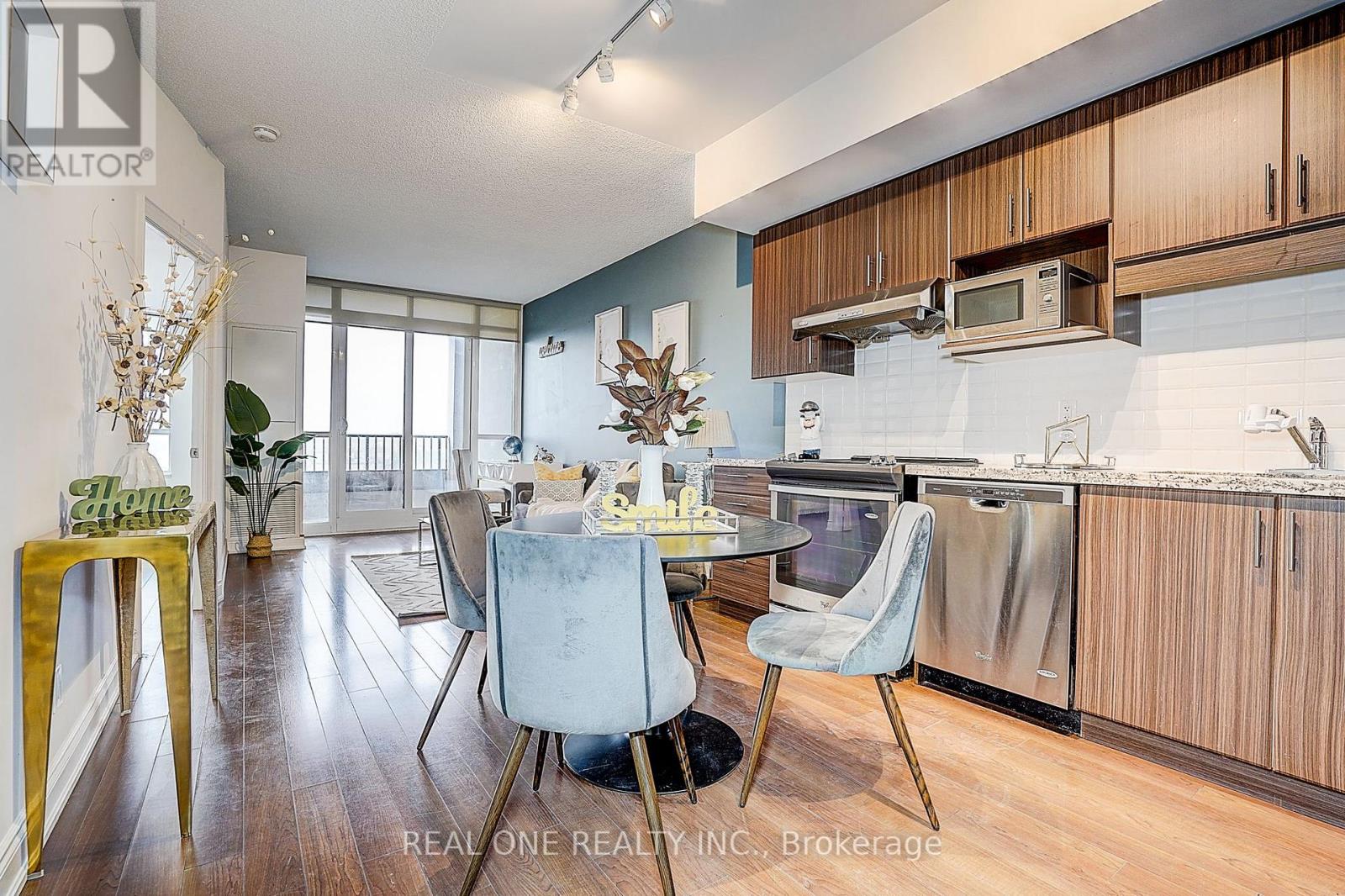 A kitchen with a dining table and chairs in the foreground.
