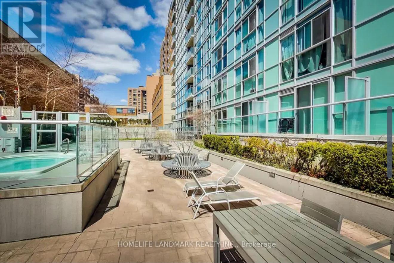 A rooftop patio with a pool and chairs.