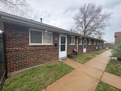 A row of houses with a sidewalk in front.