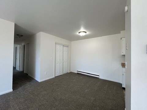 A room with a carpeted floor and a window.