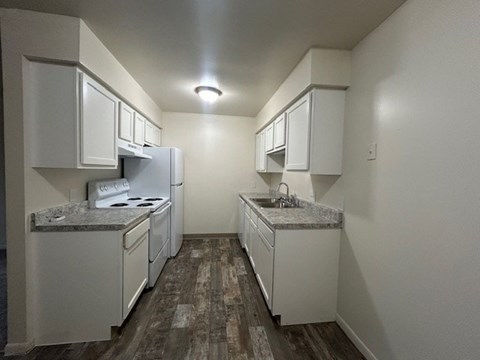 A kitchen with white appliances and cabinets.