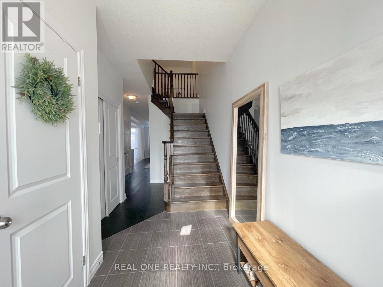 A hallway with a staircase and a wreath on the door.