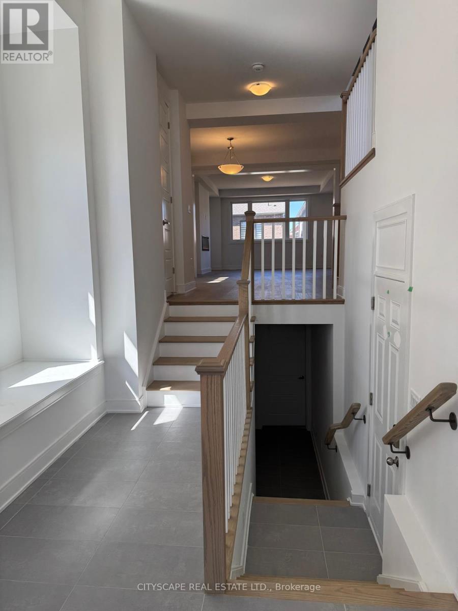 A hallway with a staircase and a door at the end.