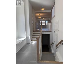 A hallway with a staircase and a door at the end.