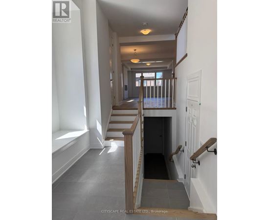 A hallway with a staircase and a door at the end.